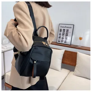 Detail shot of a black soft leather backpack with gold zippers shown in an indoor setting