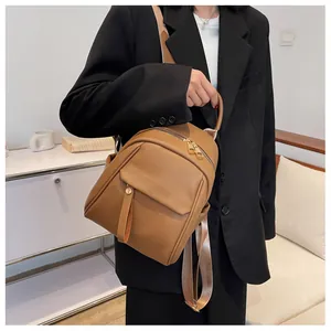 Detail of a brown lychee pattern leather backpack with gold zippers shown in an indoor setting