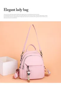 Dettaglio zaino in pelle rosa chiaro con doppia cerniera e ciondolo hello