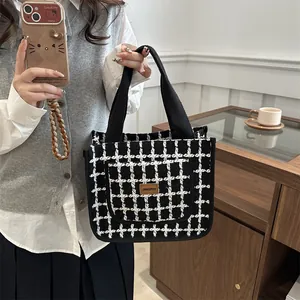 Large black and white plaid tweed tote bag for women featuring a brown leather label