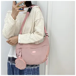 Detail of pink crescent bag with adjustable strap and matching mini coin purse charm