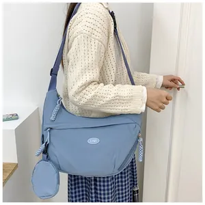 Mist blue nylon crescent crossbody bag featuring detachable coin purse and brand logo