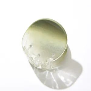 Dettaglio macro di molletta rotonda per capelli con sfumatura verde lime trasparente