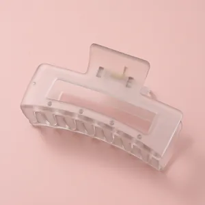 Détail d'une grande pince à cheveux rectangulaire blanc mat avec ressort métallique