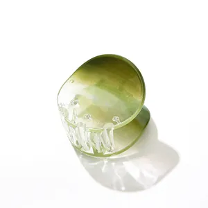 Dettaglio di un fermaglio per capelli sfumato verde chiaro con denti antiscivolo