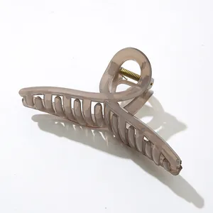 Makro-Detail einer großen bernsteinfarbenen Haarklammer mit goldener Metallfeder