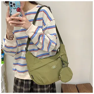 Detail of green nylon half-moon crossbody bag with detachable mini round coin pouch