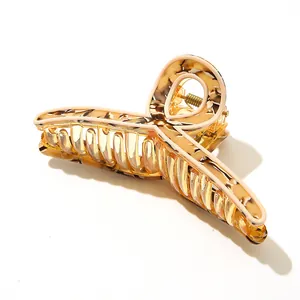 Macro view of amber acetate hair claw clip showing tortoise shell pattern and metal spring