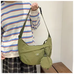 Detail of army green nylon crescent crossbody bag featuring a small round coin purse