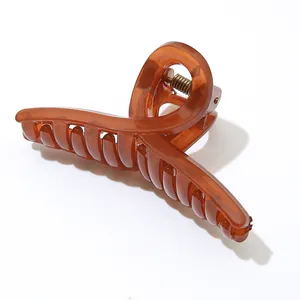 Detail der bernsteinfarbenen Haarklammer mit gekreuztem Design und Metallfeder-Struktur