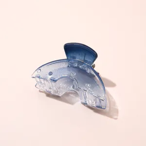 Detail van een blauwe haarklem met kleurverloop van hars en stevige metalen veer