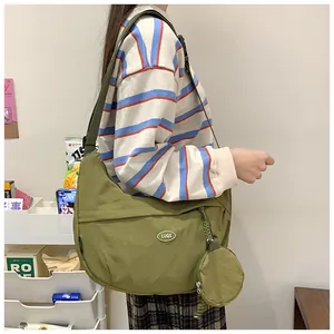 Olive green crescent nylon crossbody bag with adjustable strap and small round pouch