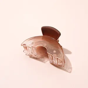 Detailopname van een amberkleurige mini-haarklem met gegraveerd modelnummer K-003