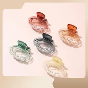 Detailed macro view of transparent resin hair claws in five gradient colors with ribbed texture