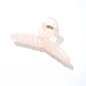 Vue détaillée d'une grande pince à cheveux rose givré avec ressort métallique doré