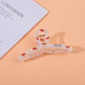 Detail of colorful acrylic hair claw with watermelon print and Barrette La France text