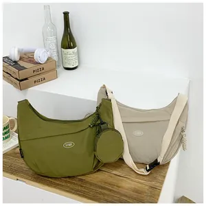 Detail of olive and beige nylon crescent bags with adjustable straps and coin pouches
