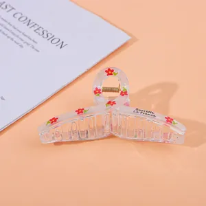 Detail of transparent large hair claw clip with red floral print and metal spring