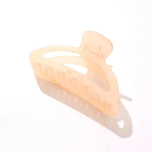 Primer plano de pinza de pelo acrílica color melocotón con fuerte muelle metálico