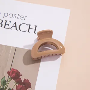 Gros plan d'une mini pince à cheveux en acrylique kaki brillant sur fond de rose