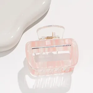 Detail of pink striped acrylic hair claw clip with square hollow design and metal spring