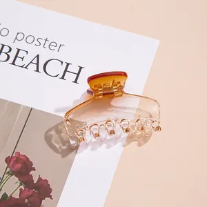 Macro shot of an amber gradient hair claw clip with a polished finish on a magazine page
