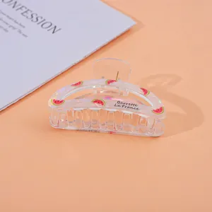 Detailed close-up of a clear acrylic hair claw clip with a cute watermelon print pattern