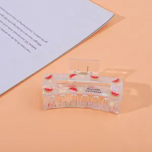 Detailed close-up of a pearlescent watermelon acetate hair claw clip with French text
