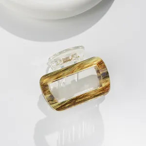 Detail view of square marble pattern hair claw clip with golden metal spring