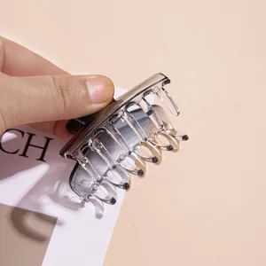 Detail of smoky gray translucent square hair claw clip held to show texture and grip