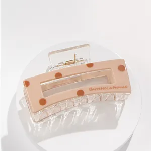 Close-up of nude polka dot acrylic hair claw clip with Barrette La France lettering