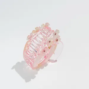 Detail of pink gradient flower hair claw clip with rhinestones and acrylic petals