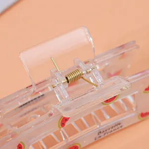 Transparent acrylic hair claw clip with watermelon pattern and gold spring detail