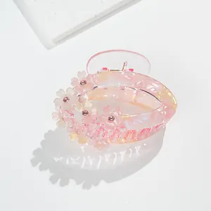 Detail of pink floral hair claw with sparkling rhinestones and marble texture resin