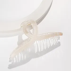Dettaglio di un fermaglio per capelli da 13cm marmorizzato color crema su base bianca