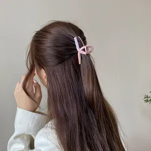 Iridescent pink cross jaw hair clip shown on model for elegant half-up hairstyle