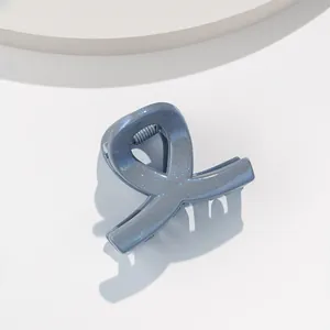 Détail de la pince à cheveux bleue pailletée avec design géométrique et fini brillant
