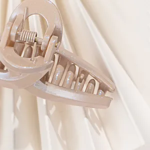 Champagne glitter claw clip with minimalist cross design and fine shimmer finish