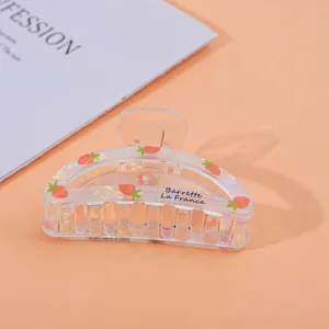 Detail of transparent strawberry hair claw clip with printed Barrette La France text