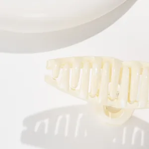 Close-up of a pearlescent cream hair claw clip with fine glitter and soft lighting