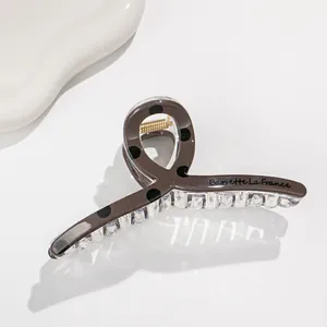 Close-up of a large polka dot hair claw clip with Barrette La France text engraving