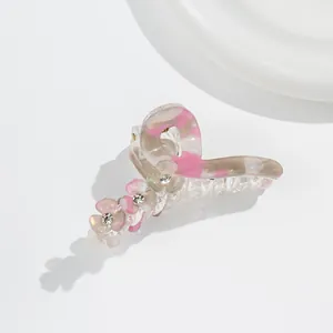 Detail of acrylic flower hair claw with marble texture and rhinestone center