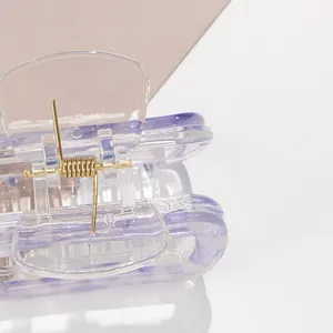 Dettaglio della pinza per capelli quadrata in acetato con motivo marmorizzato viola