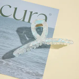 Dettaglio della pinza per capelli in acrilico con trama marmorizzata blu e bianca