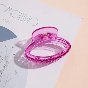 Dettaglio molletta per capelli rosa trasparente con molla in metallo su rivista