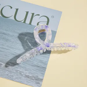 Dettaglio di un grande fermaglio per capelli marmorizzato viola con design a torsione