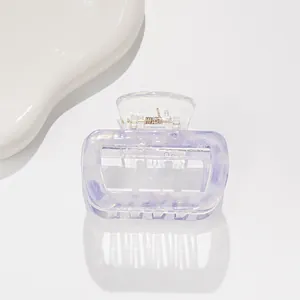 Dettaglio del fermaglio quadrato in acetato con trama marmorizzata viola iridescente