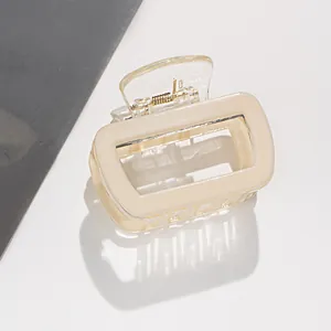 Nahaufnahme der cremefarbenen eckigen Haarklammer mit goldener Metallfeder im Design