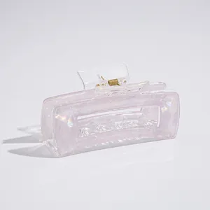 Detail of pink pearlescent rectangle hair claw clip with golden metal spring