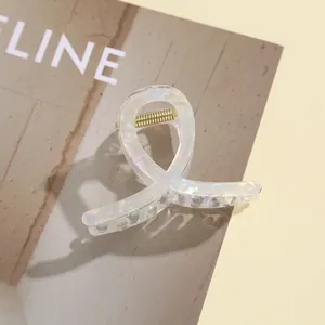 Gros plan d'une pince à cheveux en acrylique nacré avec finition irisante